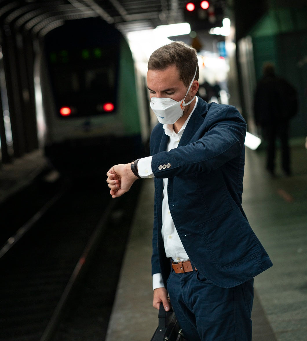 Man wearing Draeger Drager 1950 NIOSH N95 respirator mask on public transit subway train or airplane