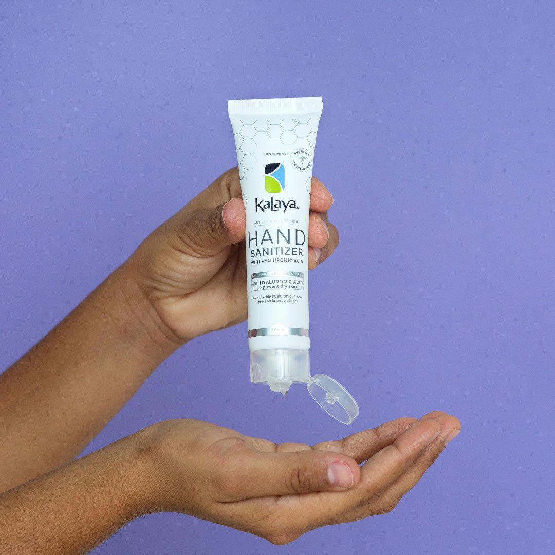 Canadian person applying 60mL Kayala travel hand sanizier from purse to hands to moisturize and sanitize hands